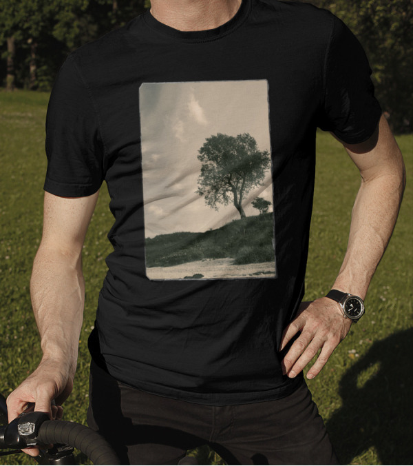 Tree On Grassy Hillside Under Cloudy Sky T-Shirt
