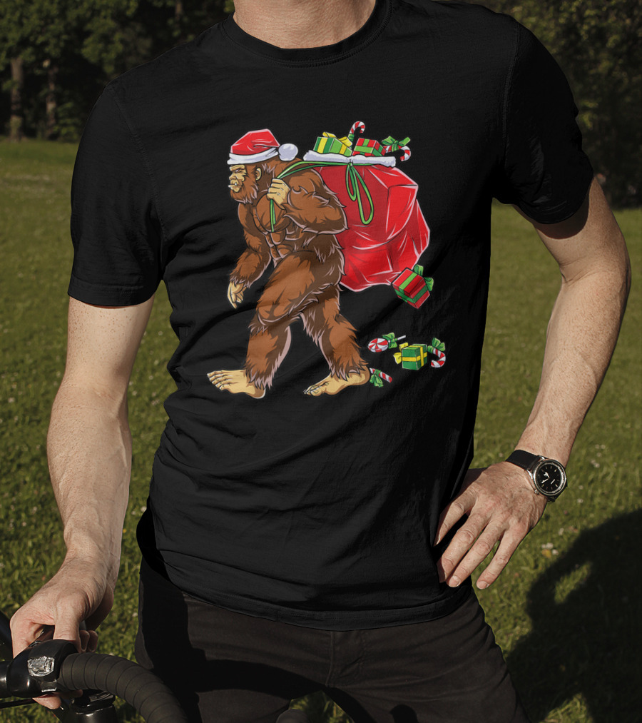 Bigfoot Santa With Giant Red Christmas Bag And Green Gifts Wearing Xmas Hat T-Shirt