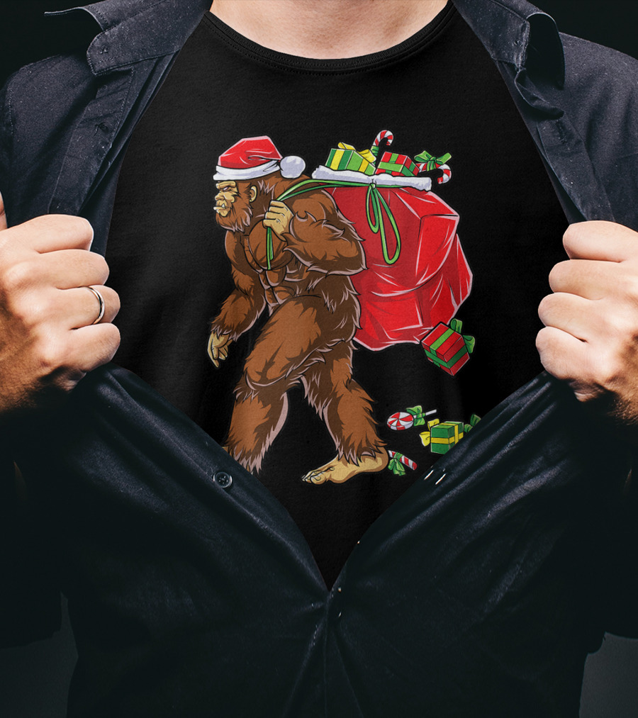 Bigfoot Santa With Giant Red Christmas Bag And Green Gifts Wearing Xmas Hat T-Shirt