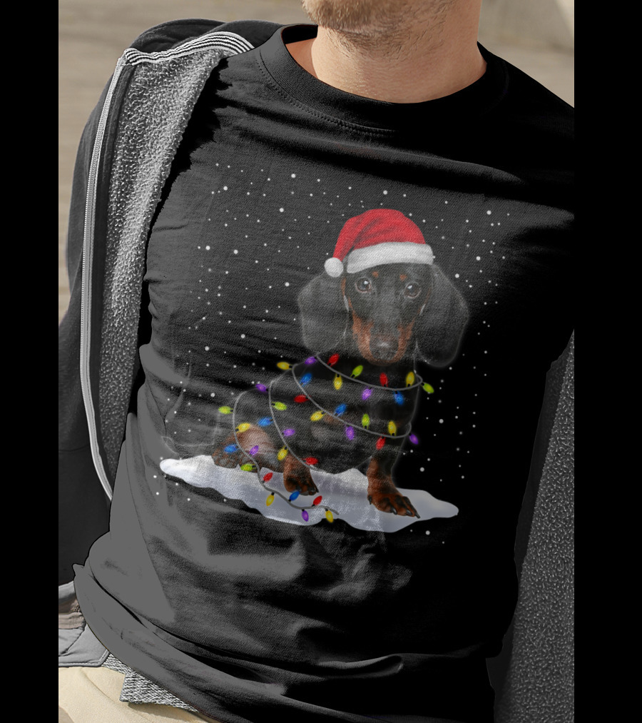 Dachshund Santa Hat Wrapped In Christmas Tree Lights In Snow With Falling Snowflakes T-Shirt
