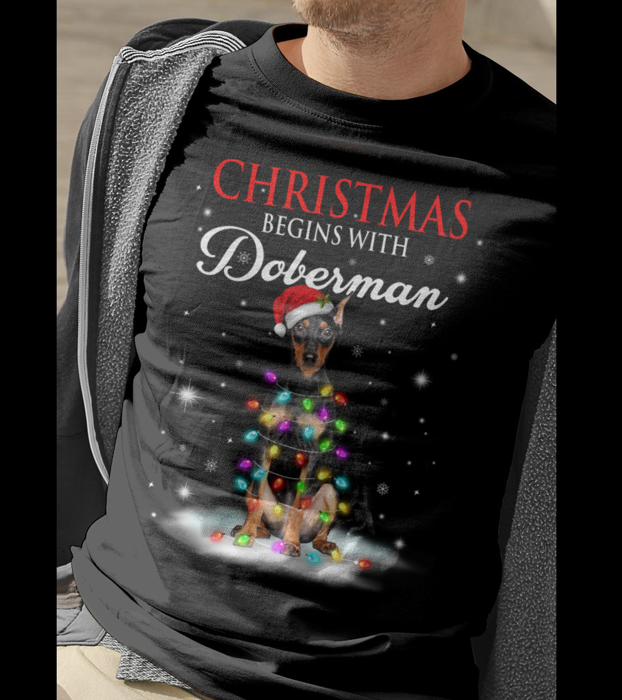 Christmas Begins With Doberman Wrapped In Holiday Lights And Santa Hat Snowflakes T-Shirt