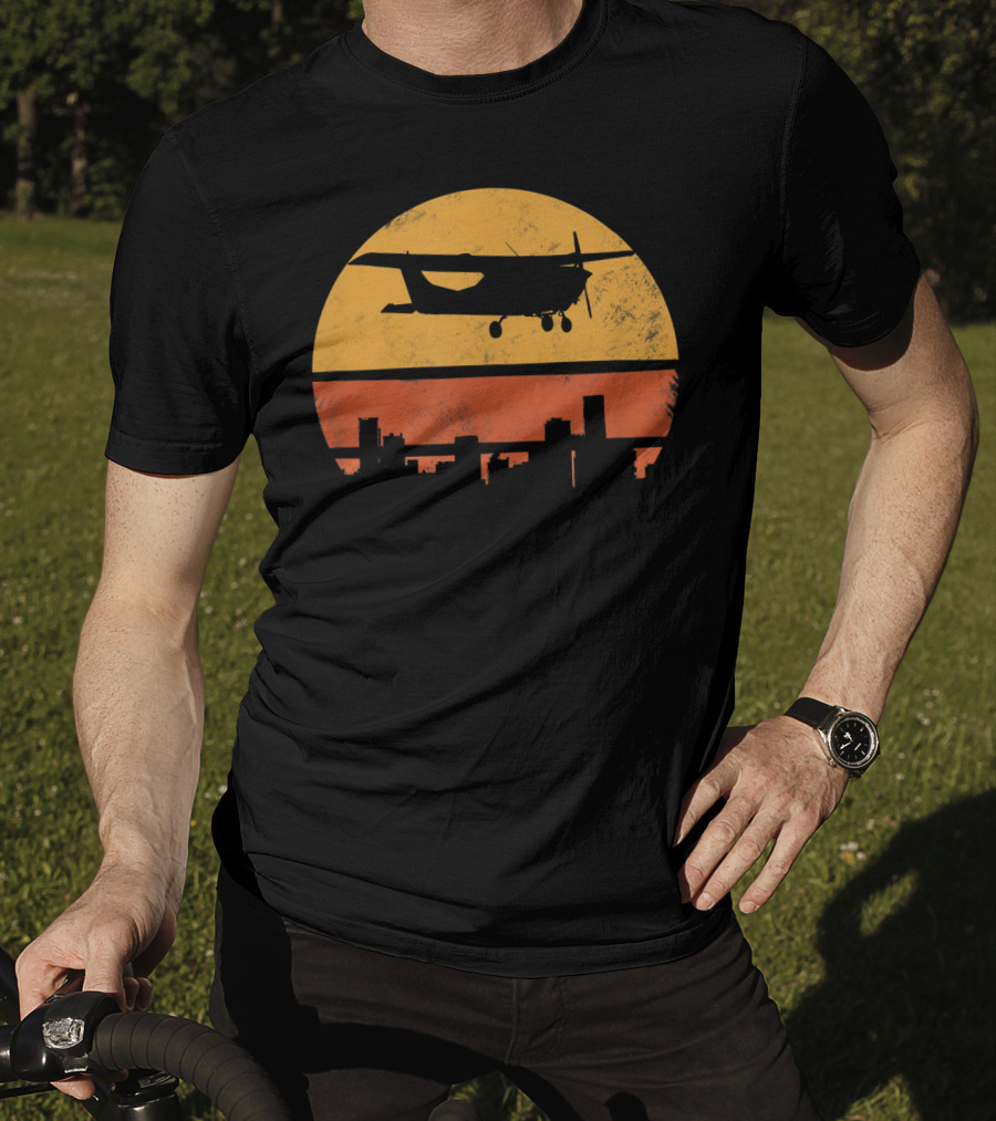 Retro Pilot C172 Flying Silhouette Over Sunset Cityscape T-Shirt