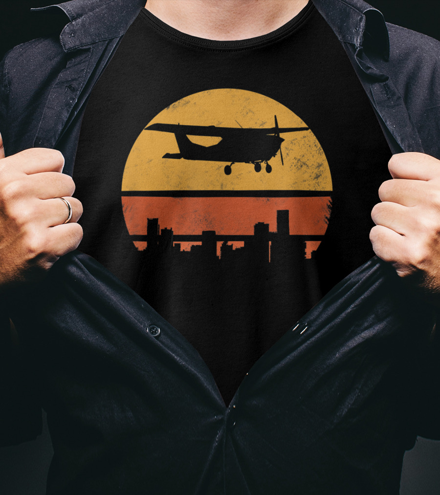 Retro Pilot C172 Flying Silhouette Over Sunset Cityscape T-Shirt