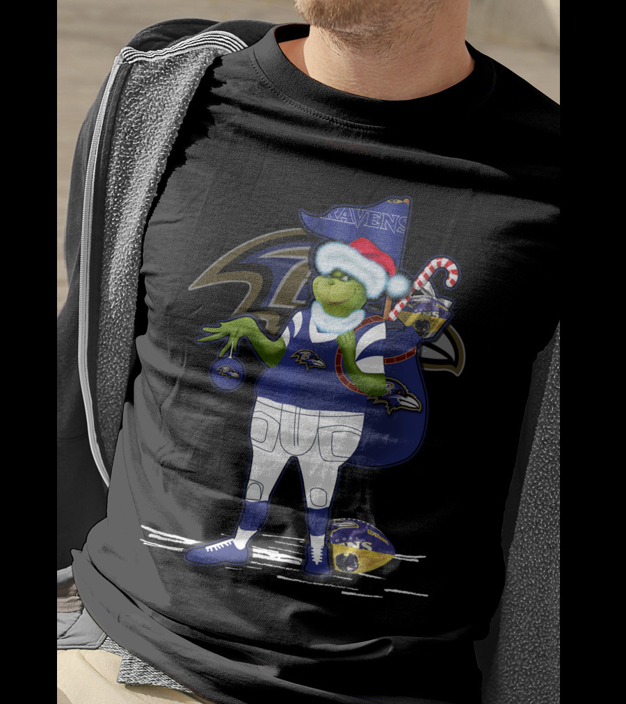 Grinch Santa Holding Candy Cane Bag And Baltimore Ravens Football In Ravens T-Shirt