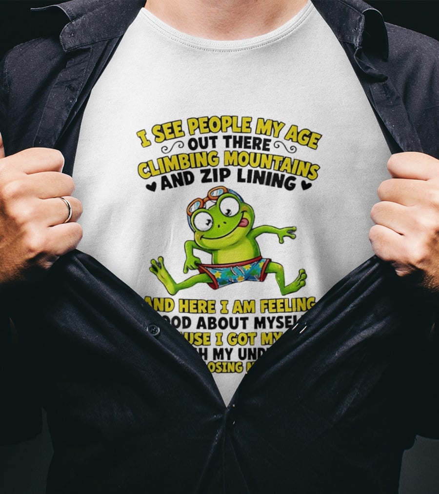 I See People My Age Climbing Mountains And Zip Lining Cartoon Frog Feeling Good Without Losing Balance T-Shirt