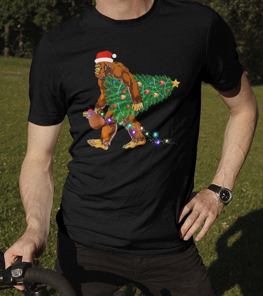 Santa Hat Bigfoot Holding Christmas Tree With Lights And Gifts T-Shirt